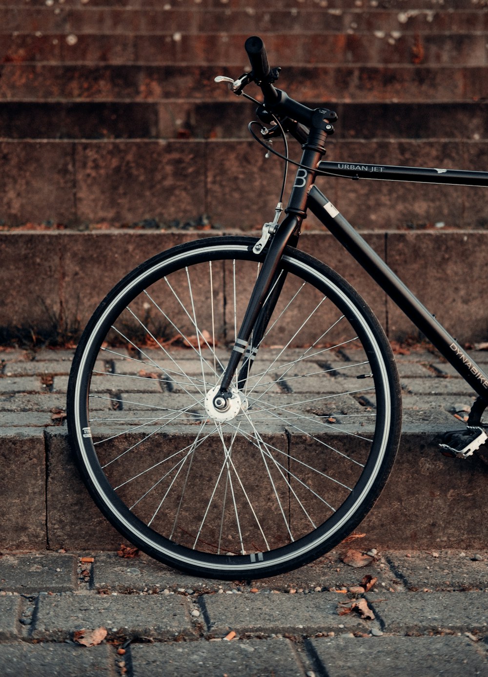schwarz-graues Fahrrad an brauner Ziegelwand