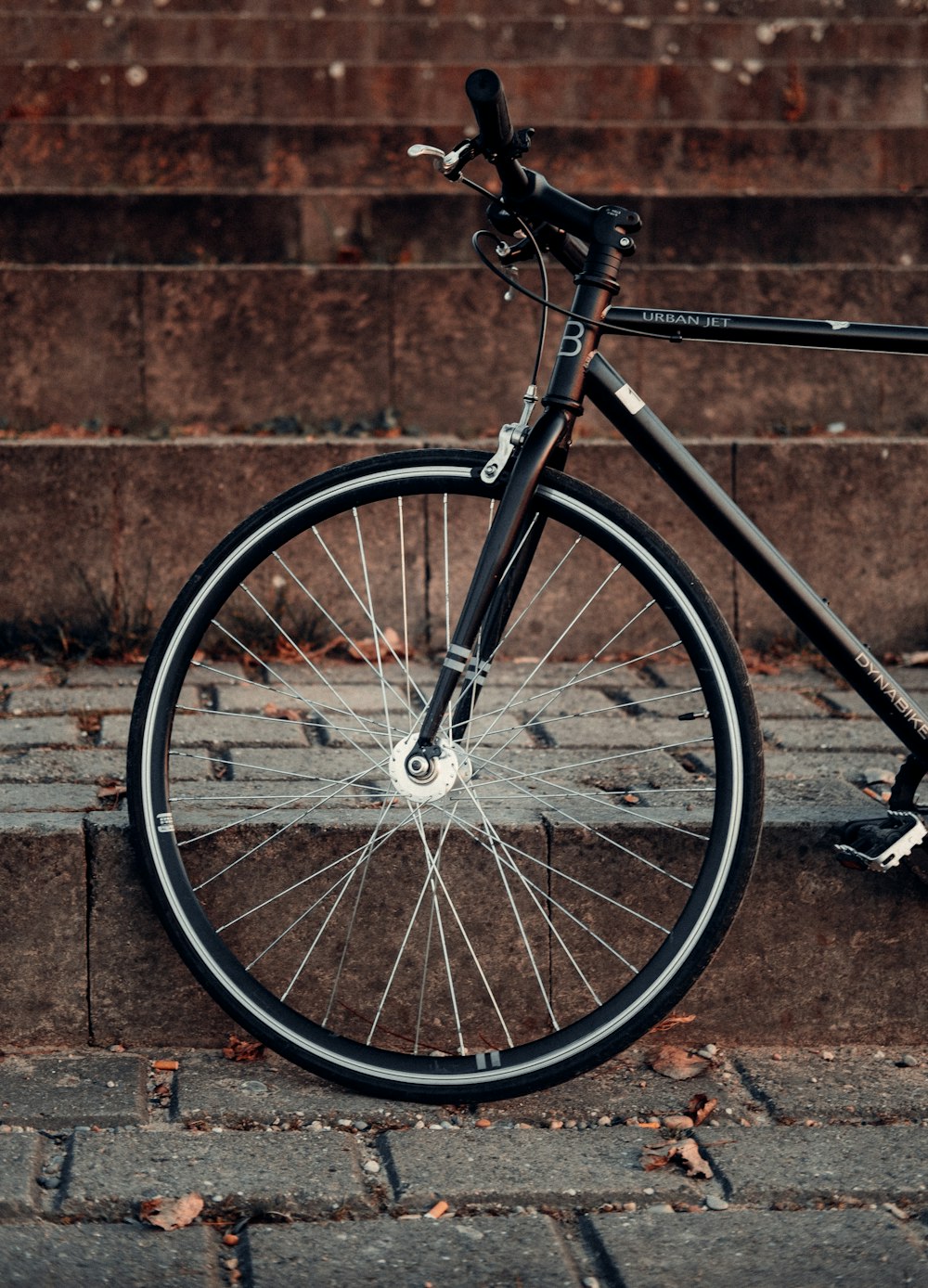 bicicleta preta e cinza na parede marrom do tijolo