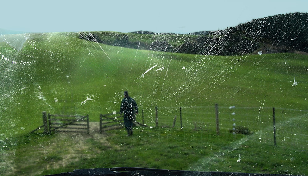 man in black jacket standing on green grass field during daytime