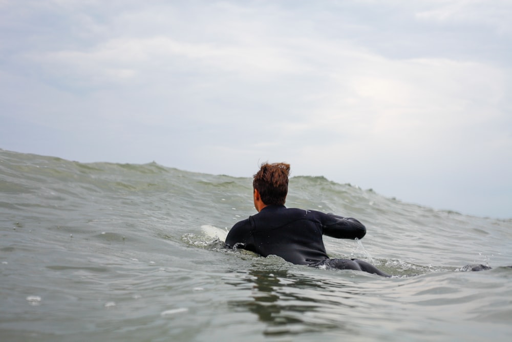 Mujer en camisa negra de manga larga en el agua