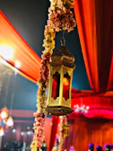 A festive setting with a model in a maroon lehenga, surrounded by golden lanterns and traditional Indian decor.
