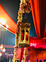 Elegant mehndi setup with traditional lanterns and rich red and gold accents under soft warm lighting.