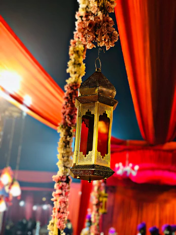 Elegant mehndi setup featuring traditional lanterns, warm lighting, and vibrant floral arrangements.