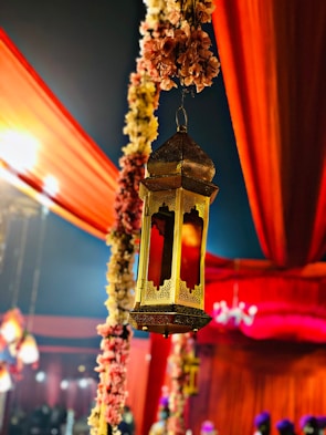 An intimate henna night setup with golden lanterns casting warm glows over guests in elegant attire.