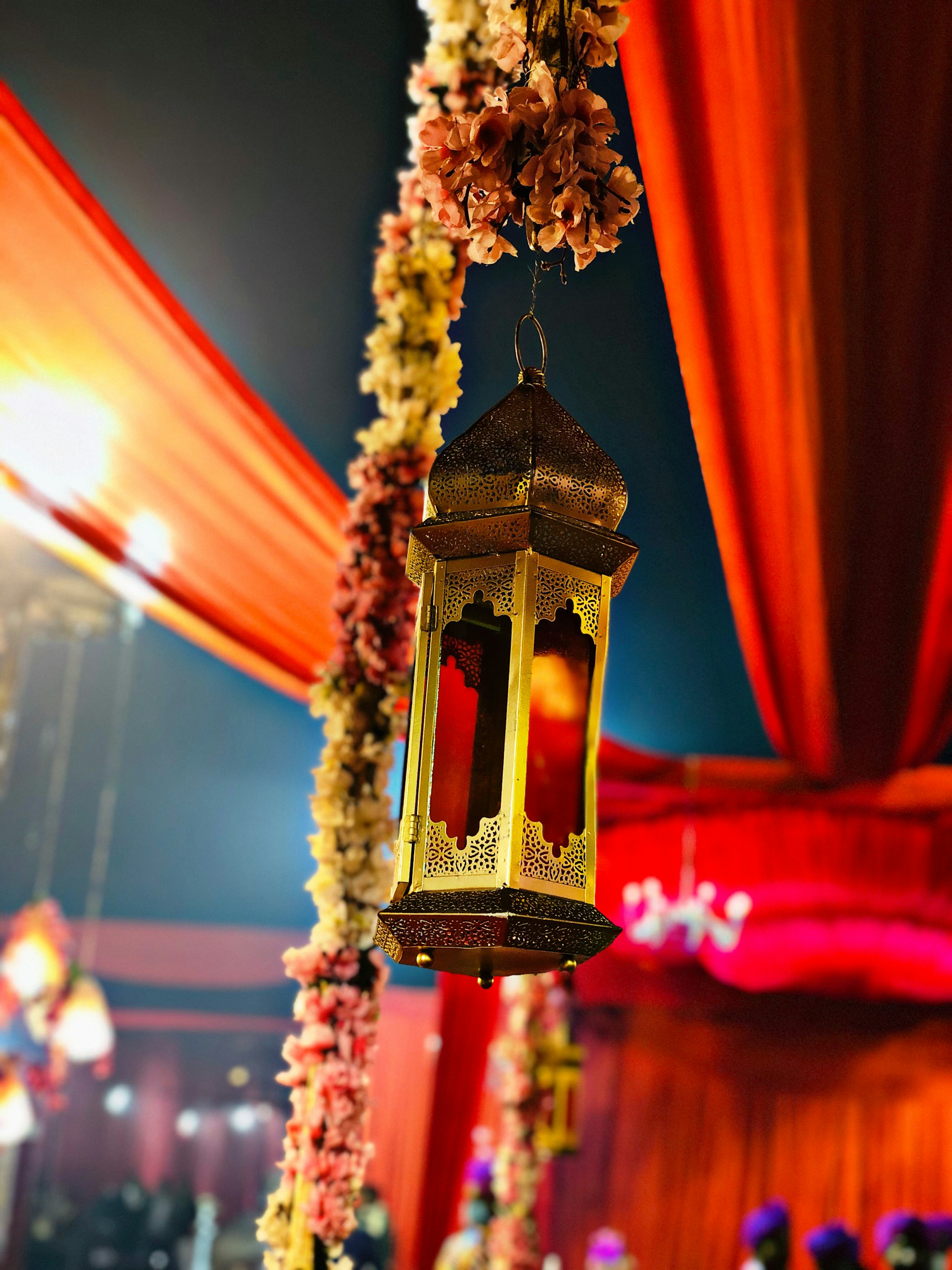 A vibrant sangeet setup featuring colorful floral arrangements, artistic lanterns, and a lively backdrop that captures the joyous spirit of the celebration.