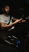 A driver checking his phone while waiting patiently inside a parked vehicle at night.