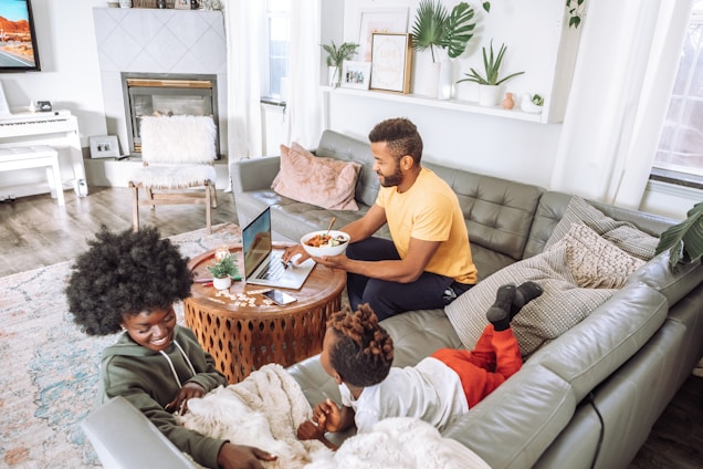 A happy family reviewing property listings on a laptop in their cozy living room.