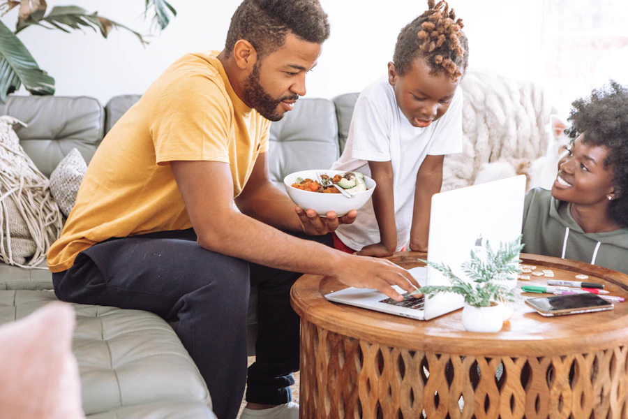 A happy family at home gathered around a laptop together