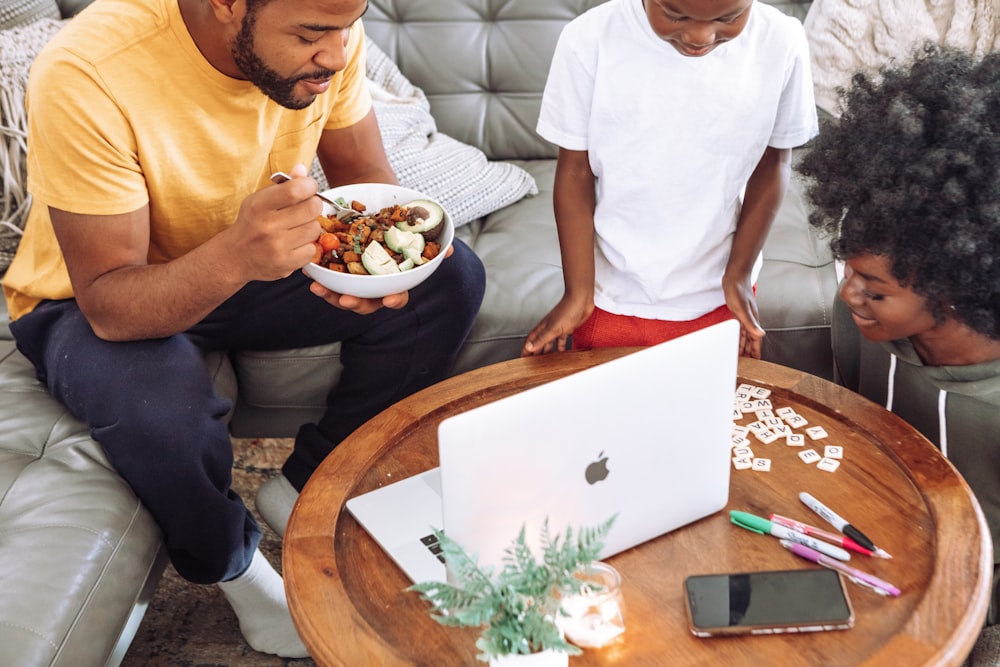 man in white crew neck t-shirt holding white ceramic bowl