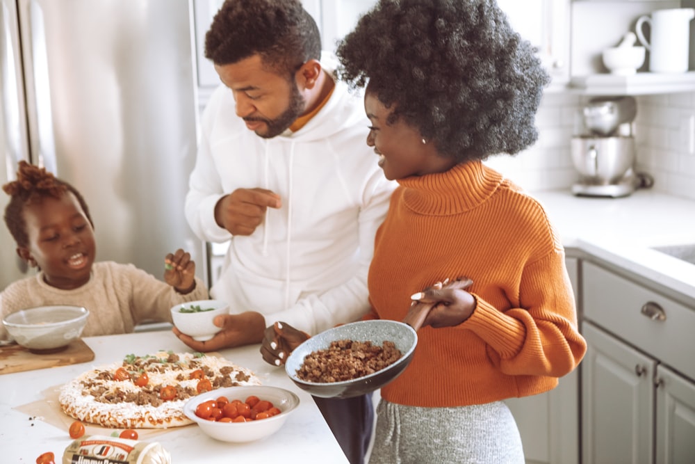 woman in orange sweater holding white ceramic bowl with food