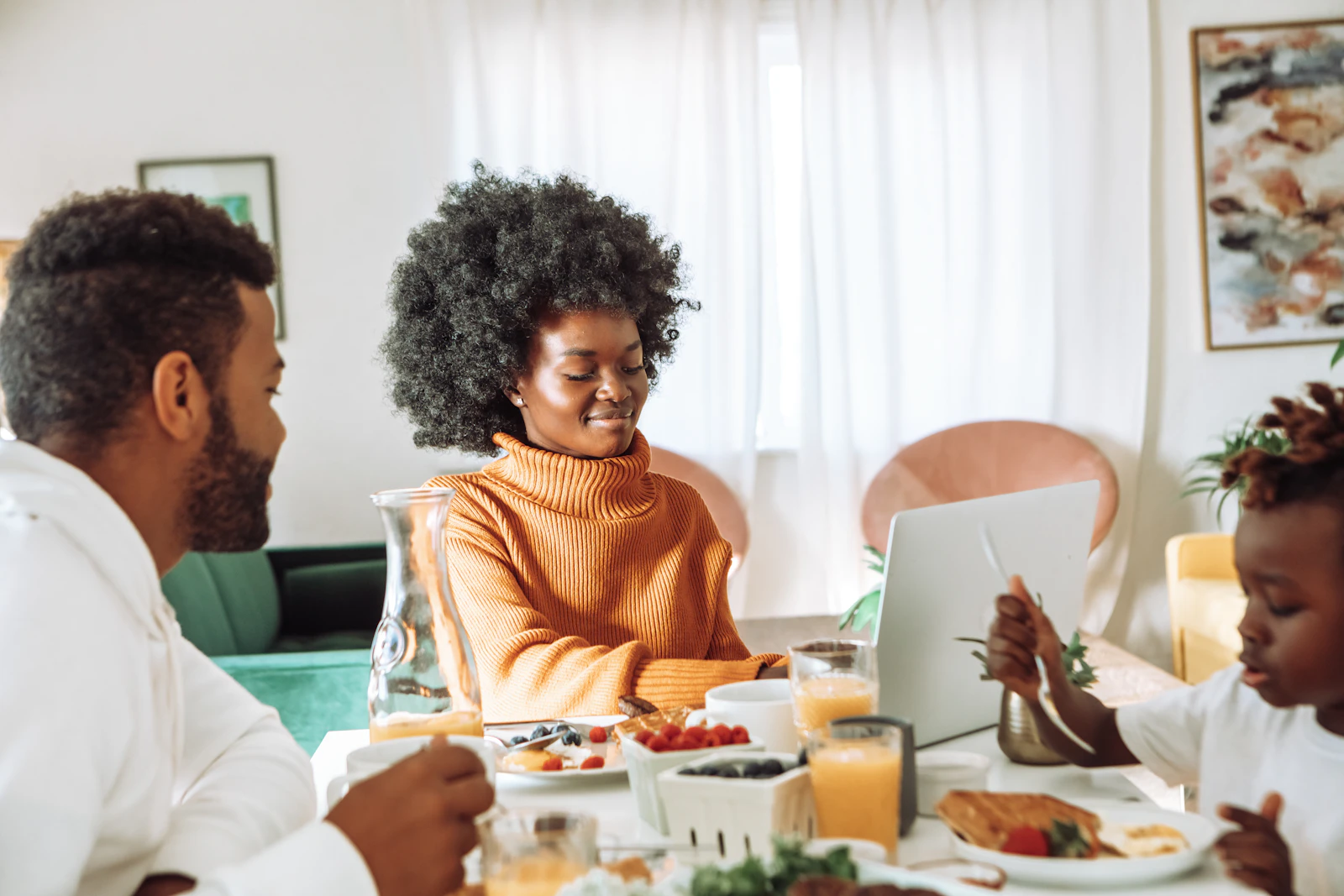 Black family sitting at a kitchen table during a financial education conversation with a professional