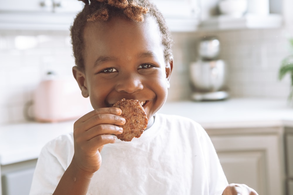 girl in white shirt holding brown bread