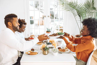 A warm, inviting family kitchen scene where parents and children share a colorful, wholesome meal together, bathed in natural light.