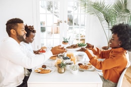 Smiling family enjoying a healthy meal together at a sunny kitchen table.