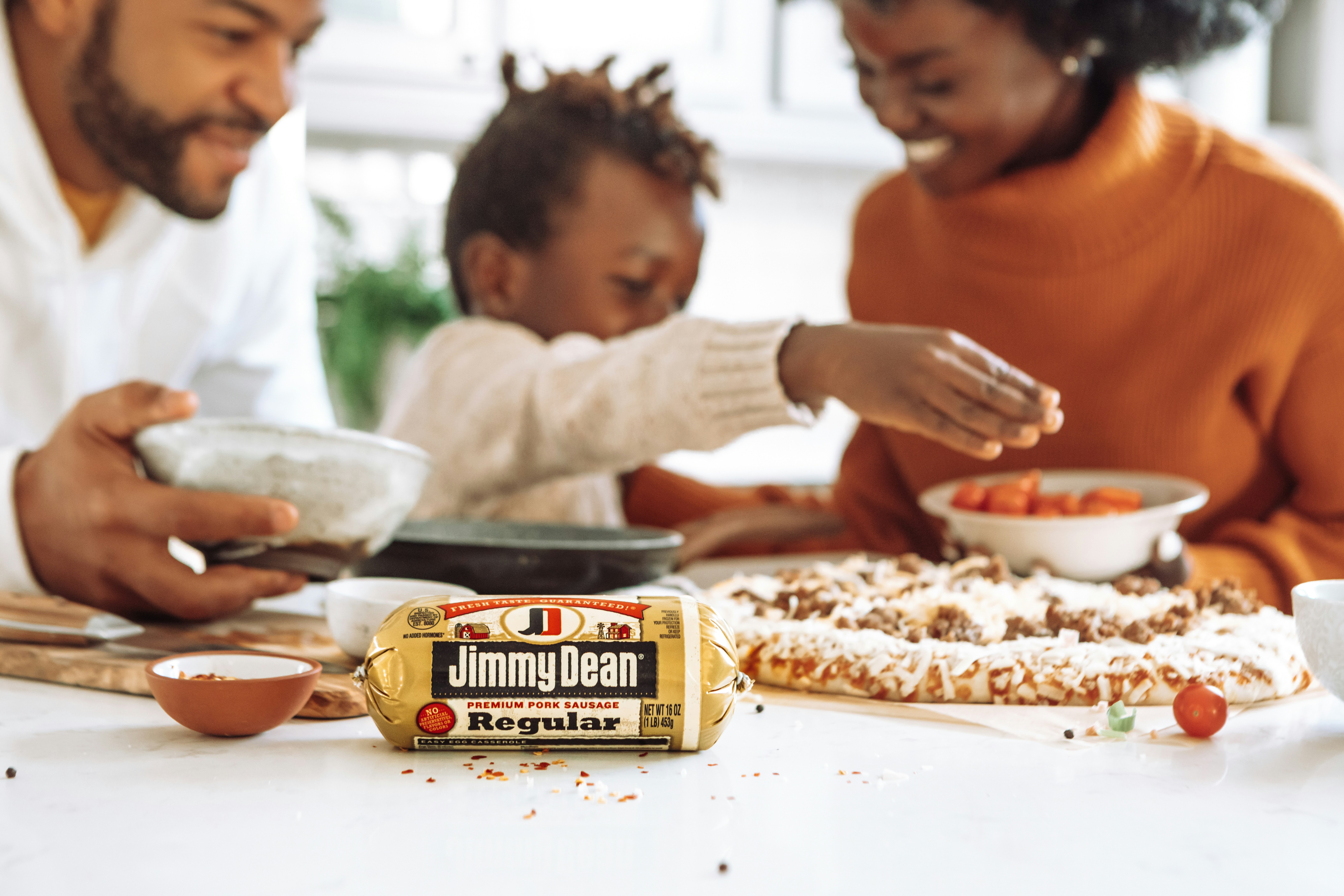 woman in white long sleeve shirt holding black and yellow labeled container