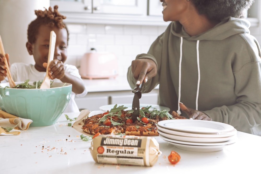 woman in brown jacket holding fork and eating pasta