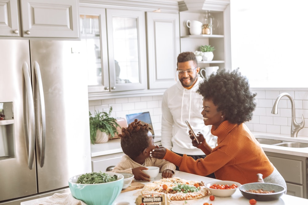 man in orange dress shirt sitting beside woman in white long sleeve shirt