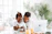 Smiling mother reading the ebook with her young son at a cozy kitchen table.