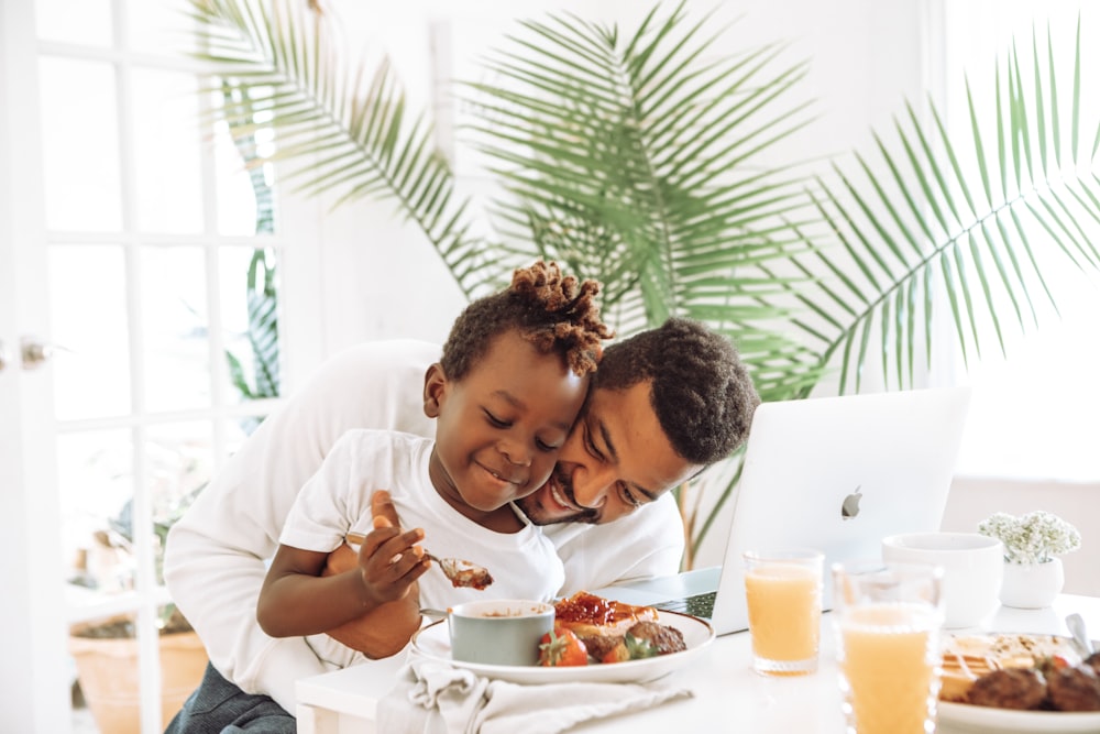 man in white dress shirt eating beside woman in white long sleeve shirt