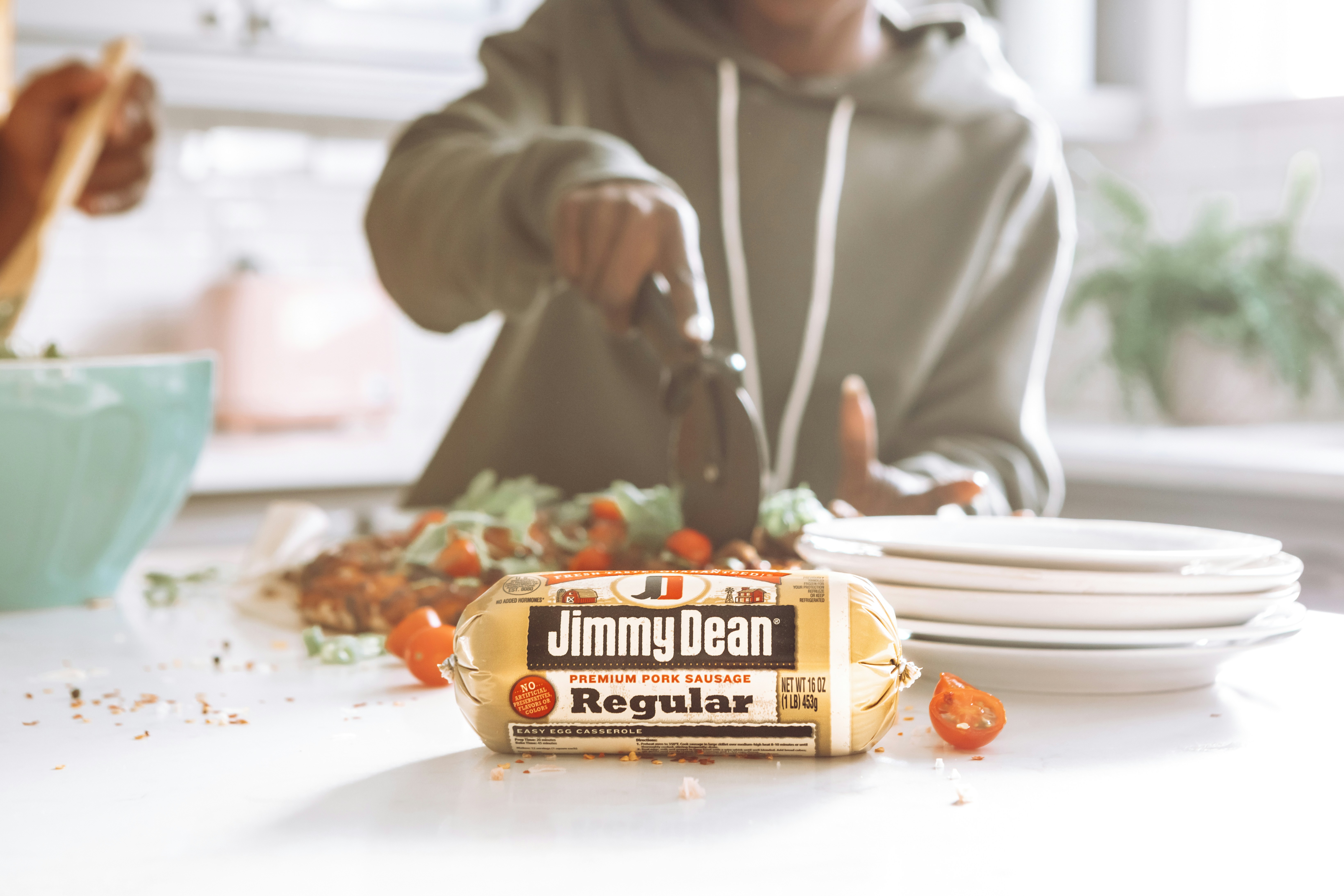man in white hoodie holding orange plastic pack