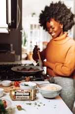 man in orange turtleneck sweater holding chopsticks