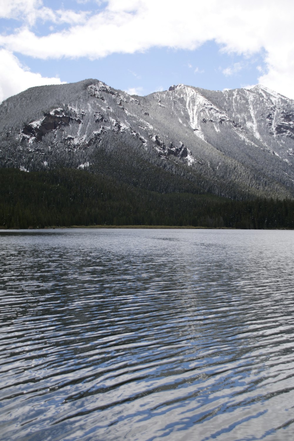 body of water near mountain during daytime