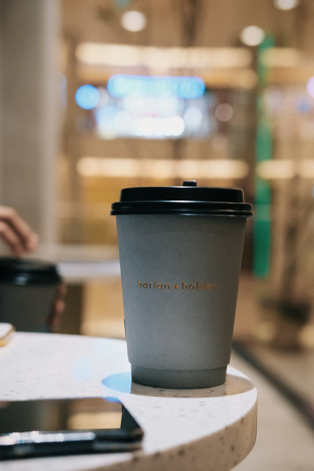 black and gray coffee cup on white table