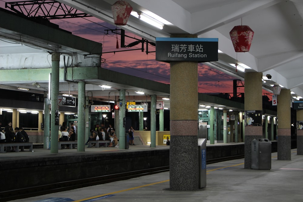 a train station with people waiting for the train