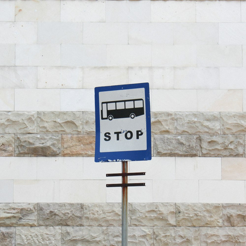 blue and white signage on white concrete wall