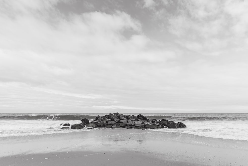 ocean waves crashing on shore under cloudy sky