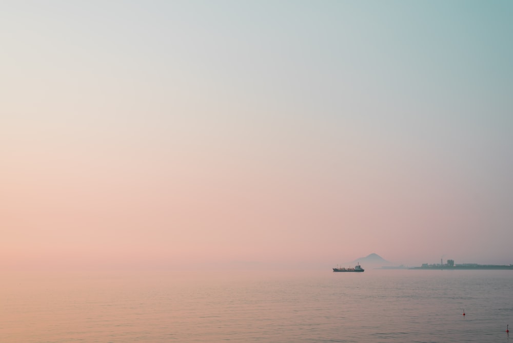 white boat on sea under white sky during daytime