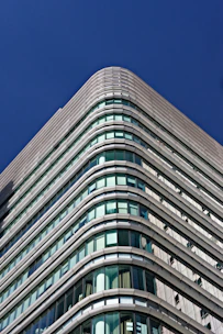 A sleek modern high-rise building with clean architectural lines under a clear sky, symbolizing strength and vision.