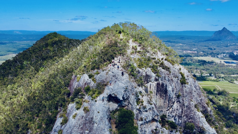 green and gray rock formation near blue sea under blue sky during daytime