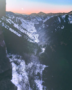 A sleek map with marked routes overlaid on a mountain landscape at dawn.