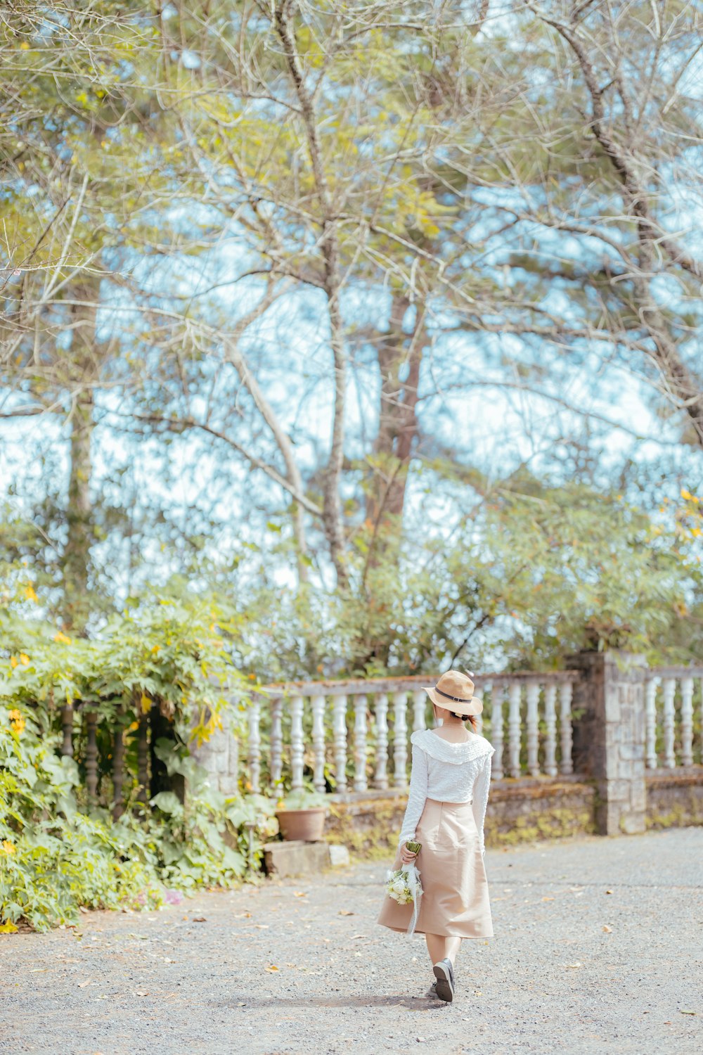woman in white long sleeve shirt standing near trees during daytime