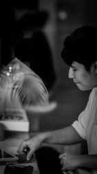 Minimalist grayscale photo of a person analyzing data on multiple screens.