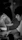 Greyscale image of a thoughtful man reviewing notes at a minimalist desk with soft daylight.