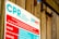 A sign detailing cardiopulmonary resuscitation (CPR) instructions, positioned against a wooden wall. The text includes warnings and response tips and highlights the importance of supervision around pools.