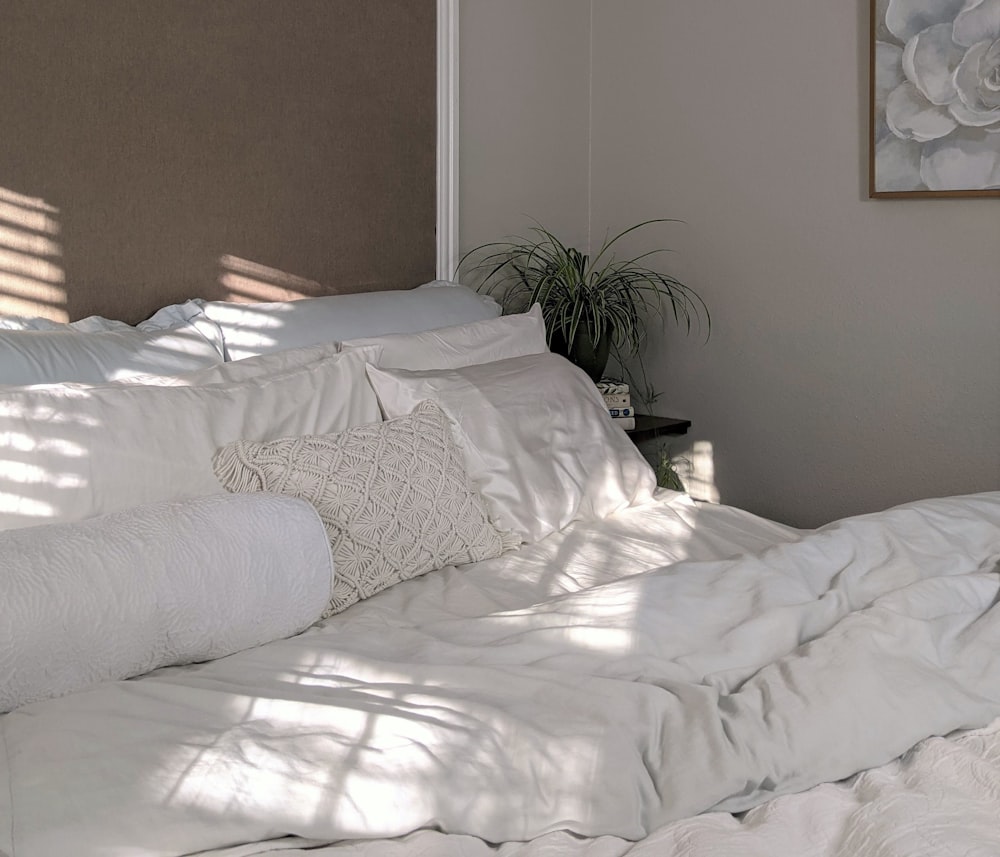 Ropa de cama blanca cerca de planta verde