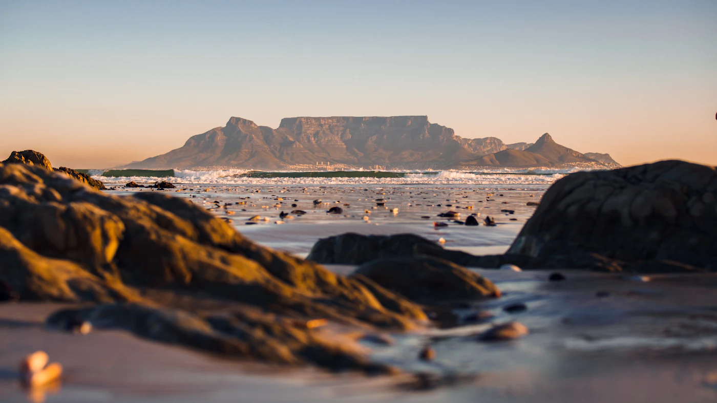 Table Mountain glowing beyond the rocky shoreline in Cape Town