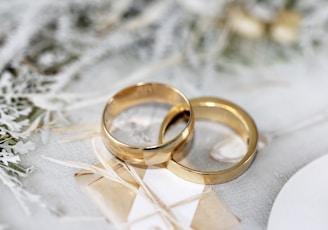 gold wedding band on white textile