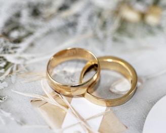 gold wedding band on white textile