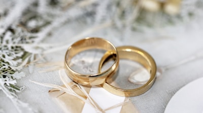 gold wedding band on white textile