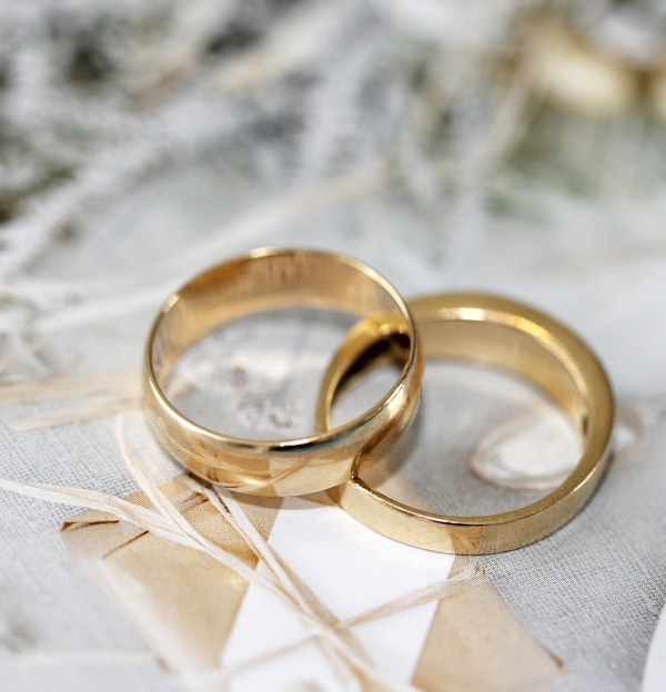 gold wedding band on white textile