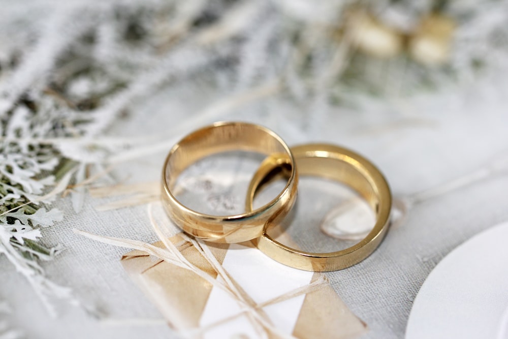 Alianza de boda dorada sobre textil blanco