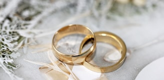 gold wedding band on white textile