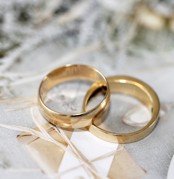 gold wedding band on white textile