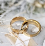 gold wedding band on white textile