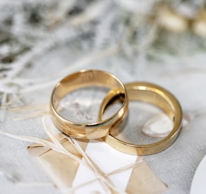 gold wedding band on white textile