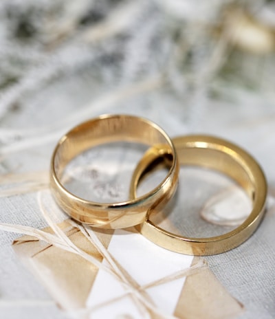 gold wedding band on white textile